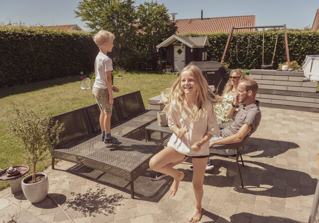 Familie sidder i solen på terassen